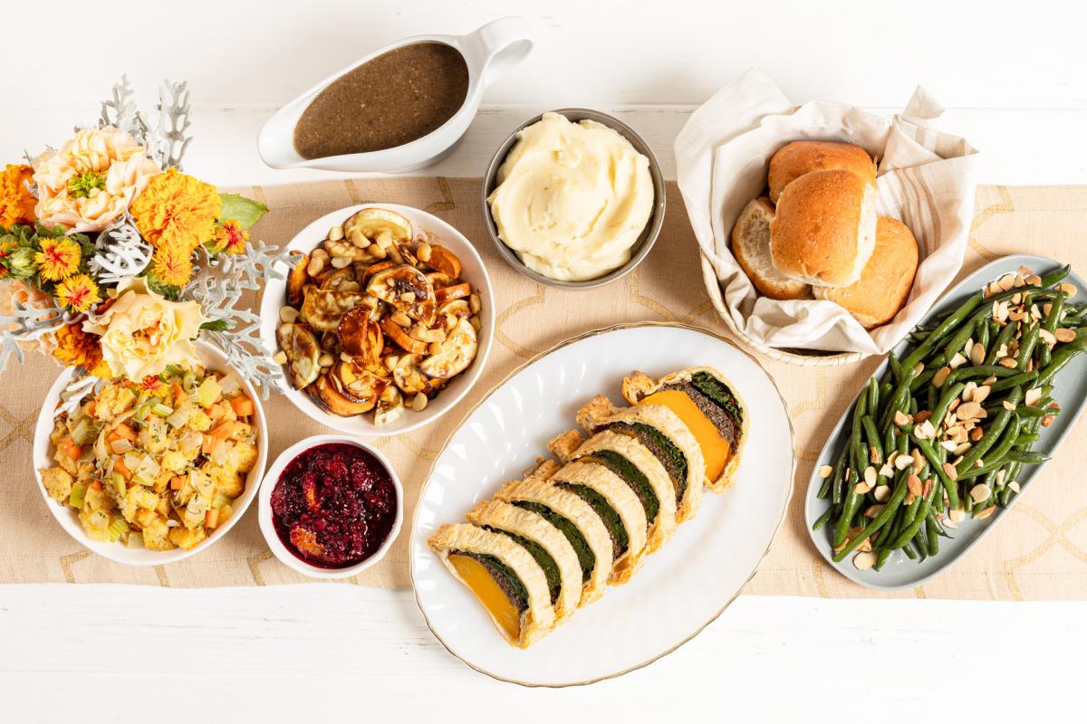 Vegan Roasted Butternut Squash Wellington, vegan garlic mashed potatoes, roasted sweet potatoes with macadamia nuts, green bean almondine, traditional stuffing, vegan mushroom gravy, wheat rolls and cranberry orange relish